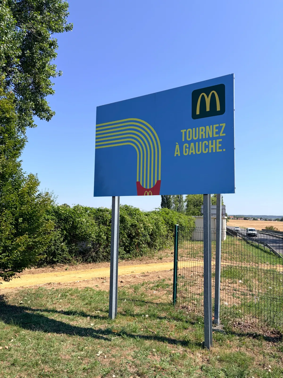 Panneau dibond McDonald's « Tournez à gauche » posé sur le parking de Carrefour Venette